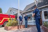 Two white men are sworn in as volunteer firefighters outside