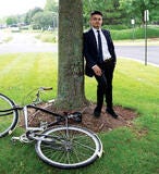 man in suit leaning against a tree