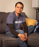 man smiling while sitting on couch