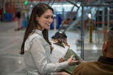 Young Woman holding clipboard and smiling in facility 