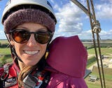 woman in helmet who is climbing a tower