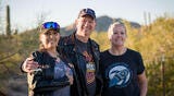 three motorcycle riders standing