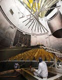 person in bunny suit inspects NASA solar arrays