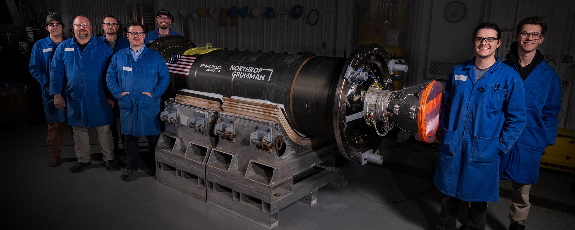 Group of seven men in blue lab coats