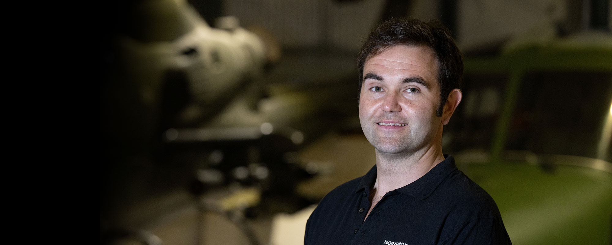 man in dark shirt smiling