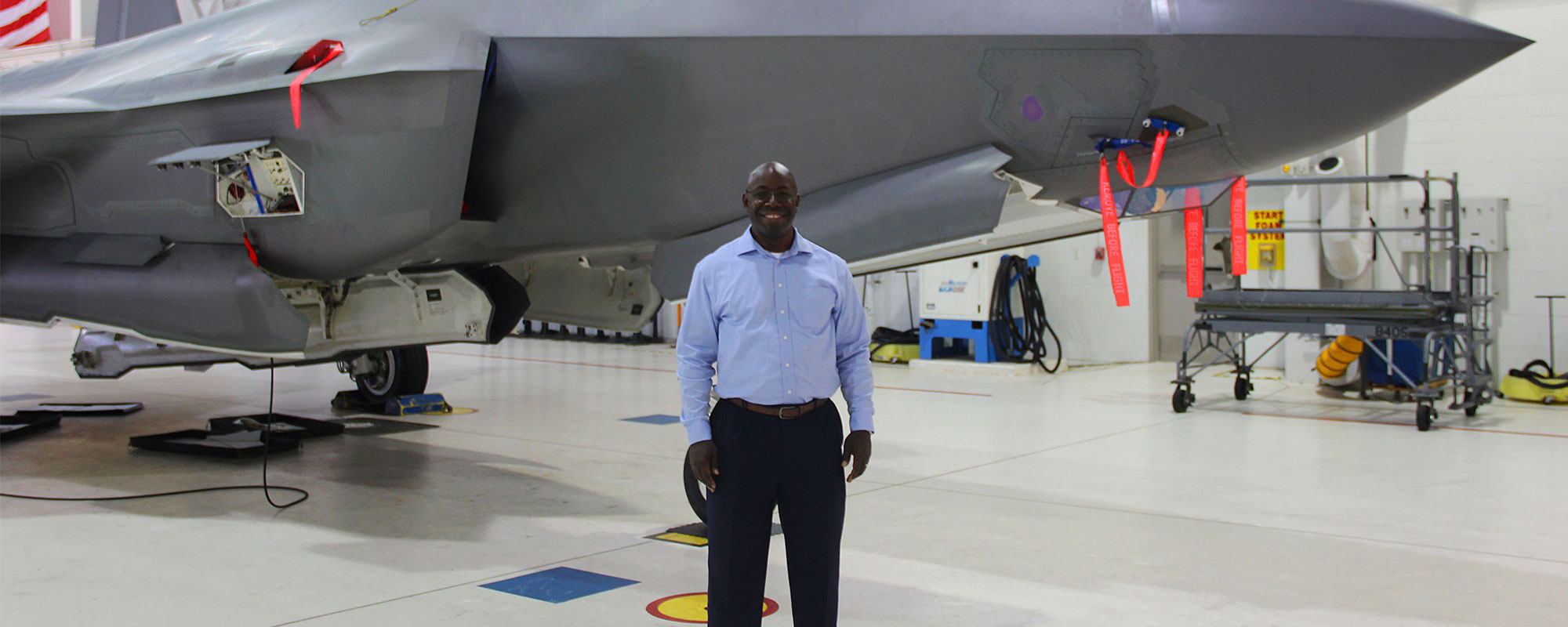black man standing in front of fighter jet