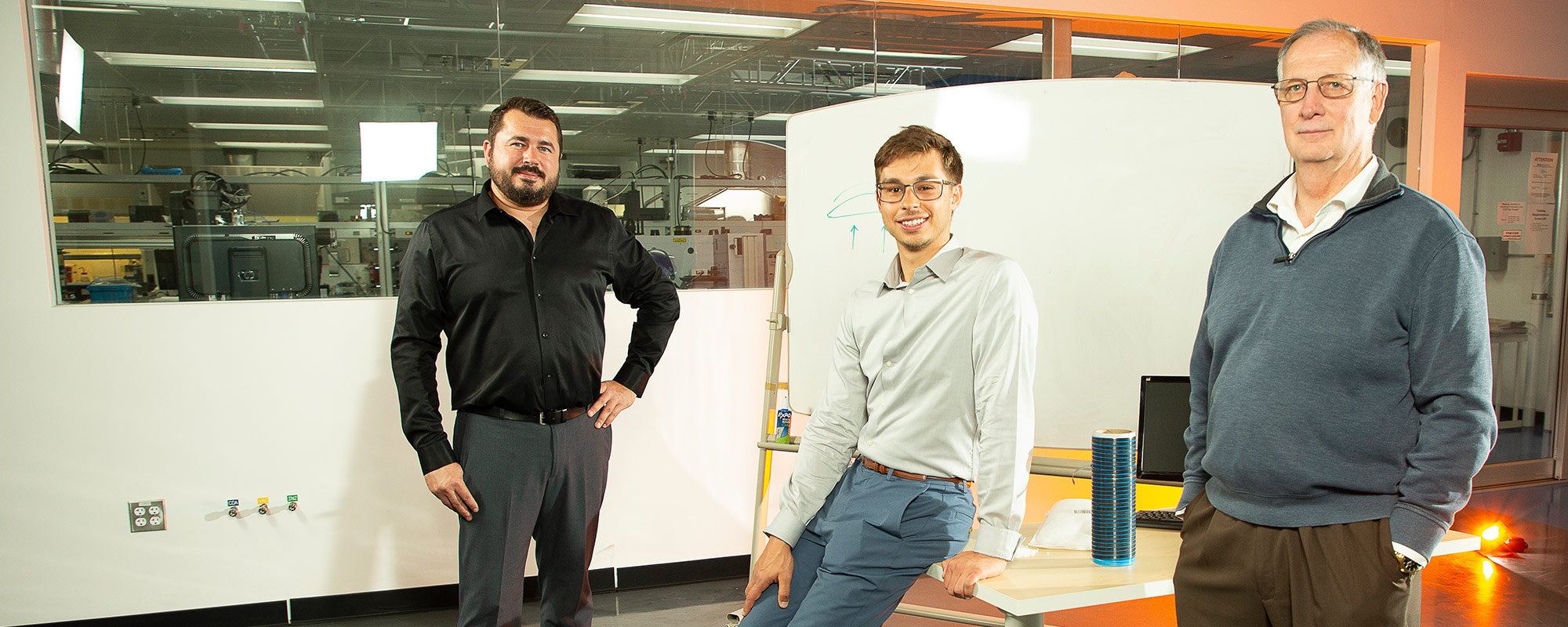 three men standing in office
