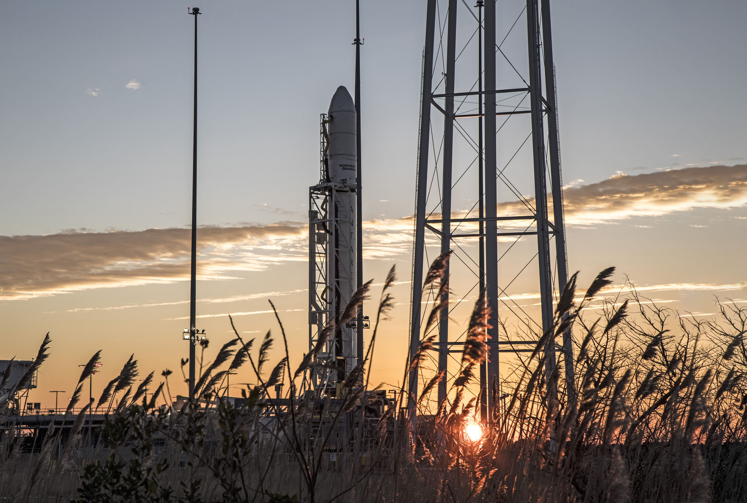 NG_15_Antares_Rocket_2 A rocket on launch pad in front of a morning sunrise