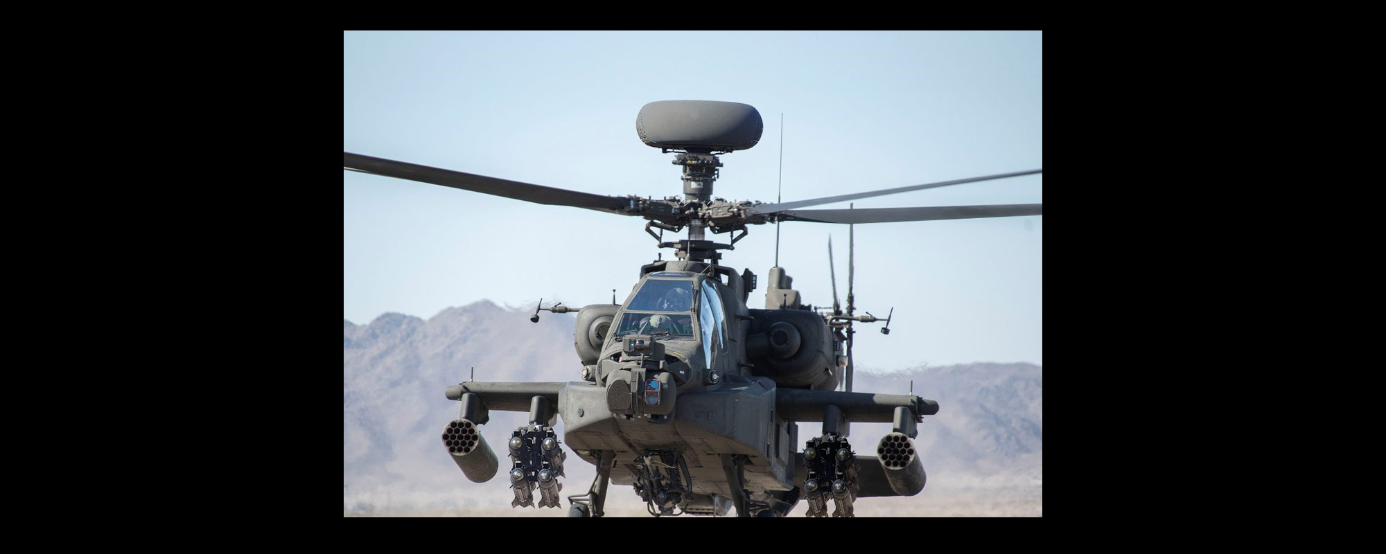 blackhawk helicopter in flight over mountains