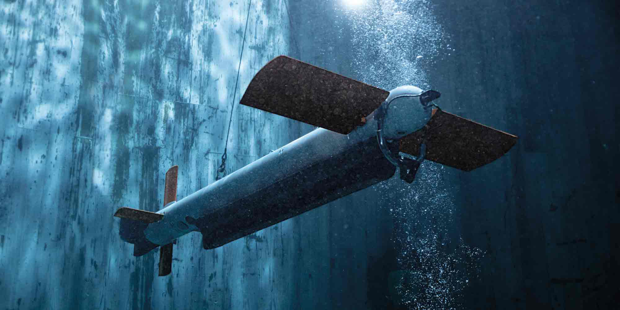 AQS-24B minehunting system operates underwater, showcasing its design and capabilities amid bubbles and illuminated water.