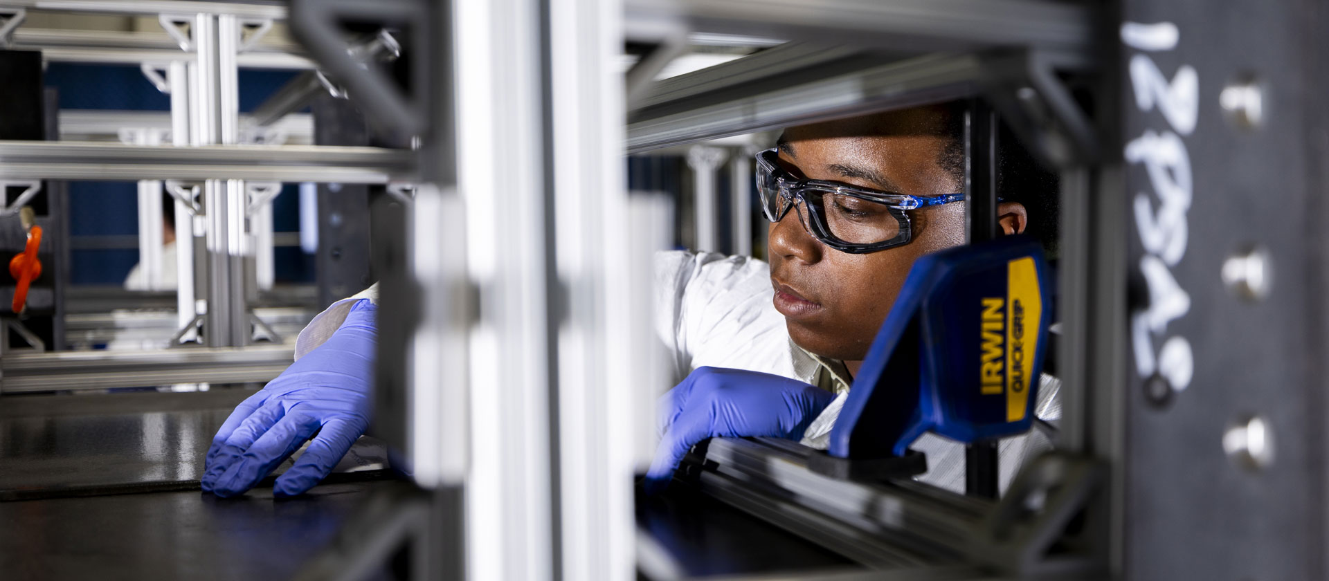 student working on equipment with protective glasses