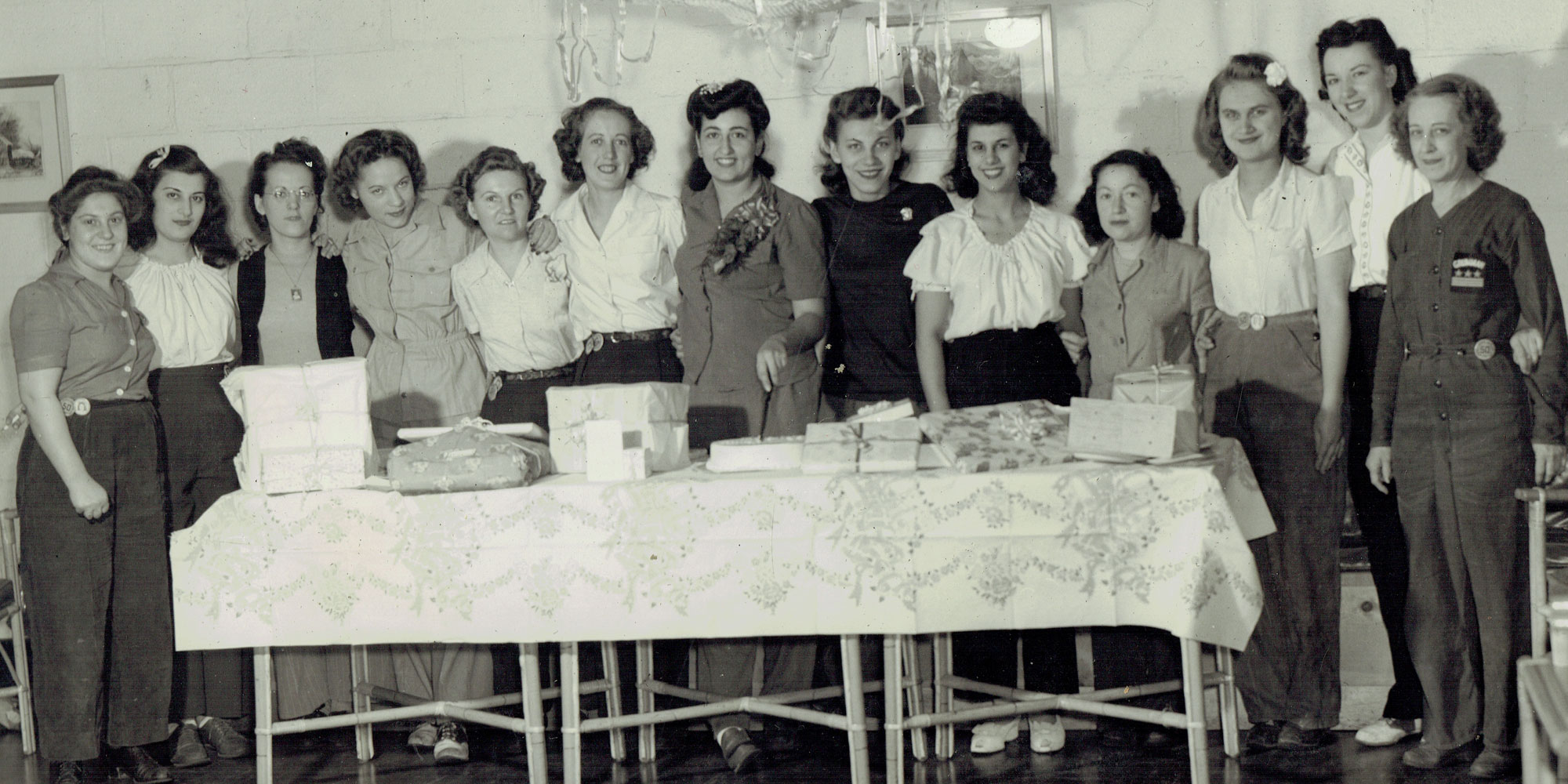 Black and white photo of workiing women during world war II celebrating with a party. 
