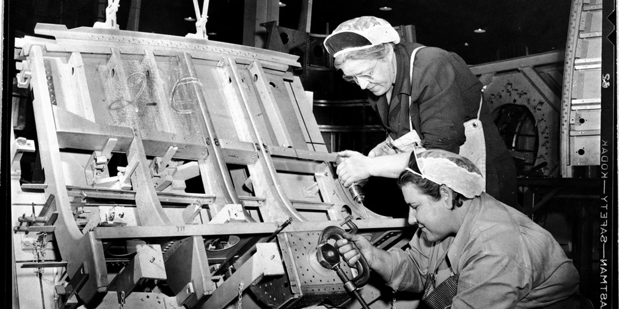 Black and White photo of woman working on world war 2 airplane.