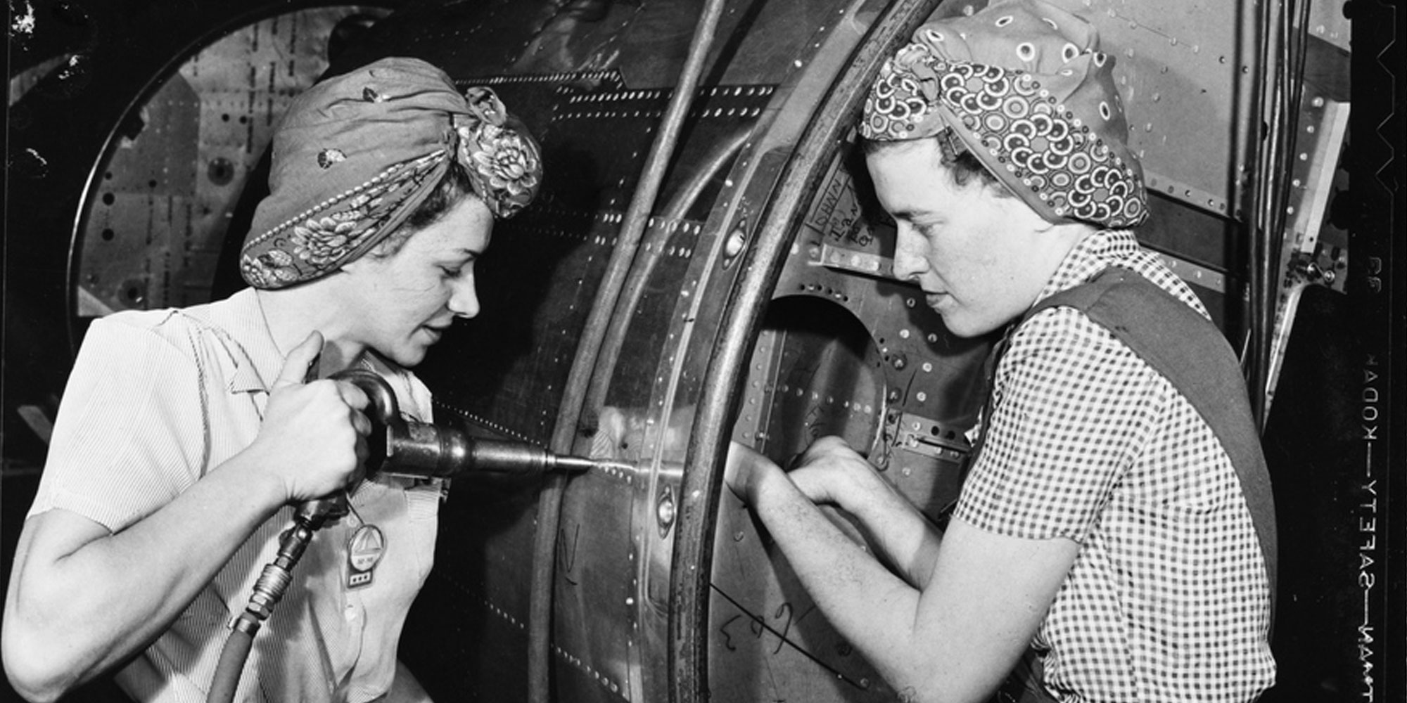 Black and White photo of women working on world war 2 airplane.