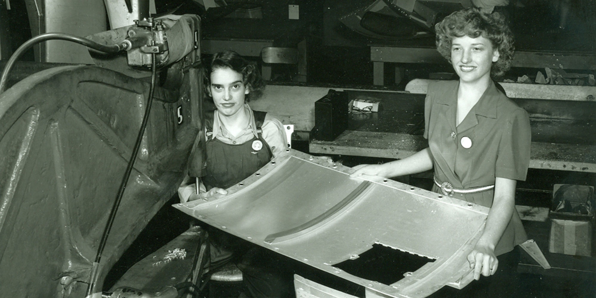 Black and White photo of women working on world war 2 airplane.