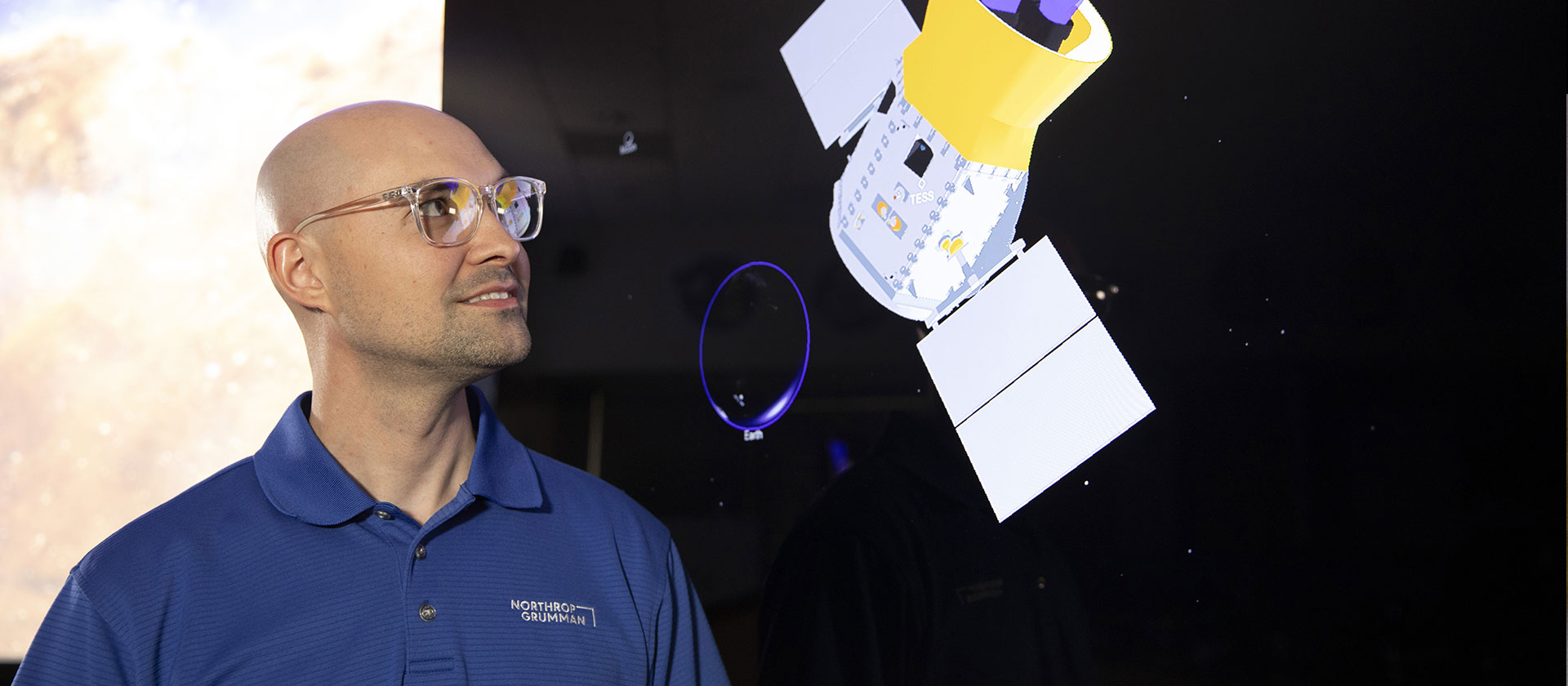 man looking at graphic representation of satellite