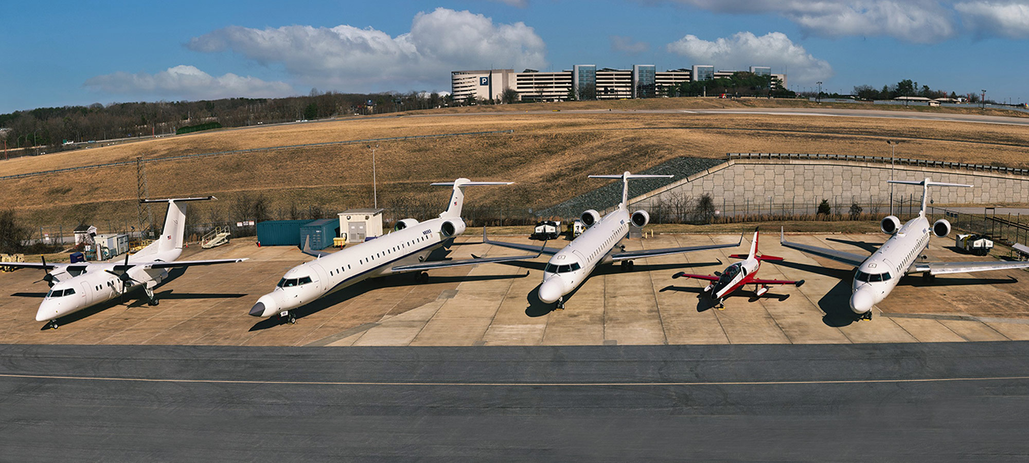 Northrop Grumman's three reconfigurable Bombardier CRJ-700s sit outside the hangar on the Baltimore campus, preparing for a flight test. three Bombardier CRJ-700 jets sit outside hangar