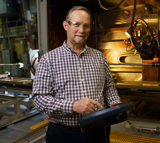Man with tablet in front of machinery