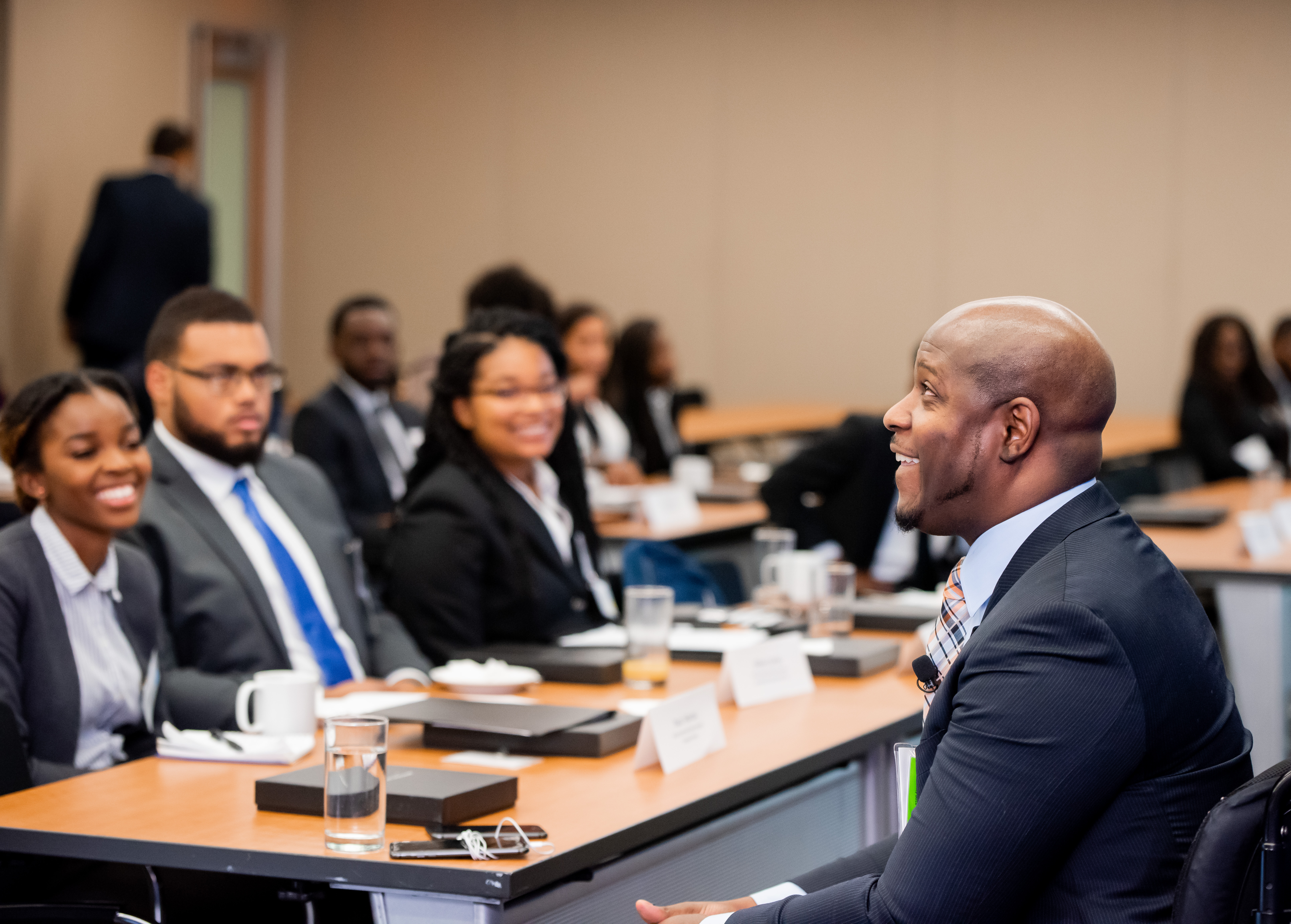 Male speaking to table of individuals