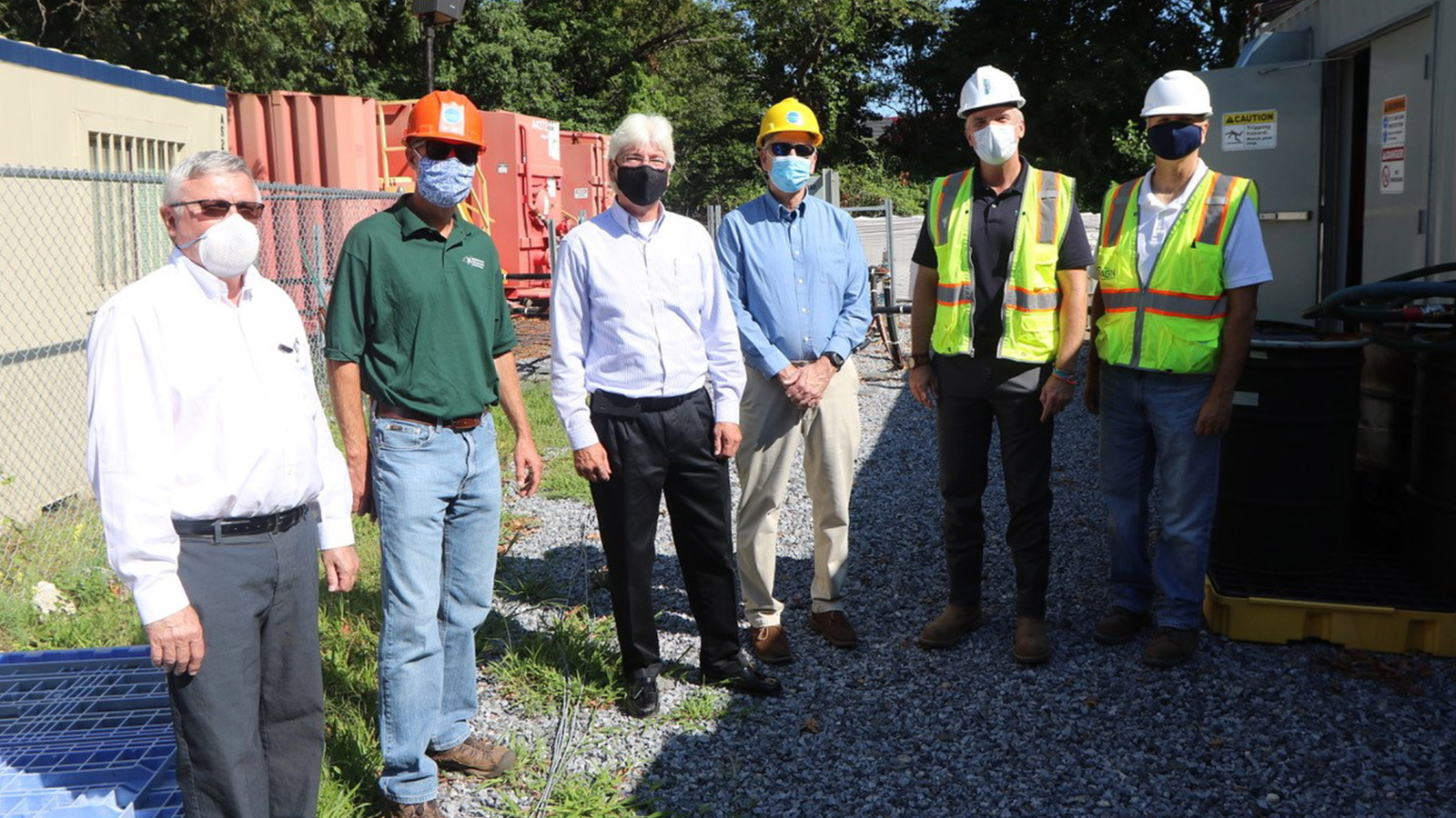 six men wearing masks and hard hats